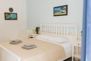 ein Schlafzimmer mit einem weißen Bett, auf dem Handtücher liegen in der Unterkunft RIO - nice room, near the sea and park in Novigrad Istria