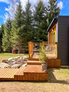 a small cabin with a deck and a grill at ARKA Puhkemajad in Päidre