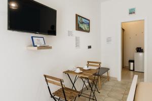 ein Esszimmer mit Tisch und Stühlen sowie einem Fernseher an der Wand in der Unterkunft RIO - nice room, near the sea and park in Novigrad Istria