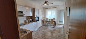 a kitchen with white cabinets and a dining table at Apartments Desiree & Daniel in Dramalj