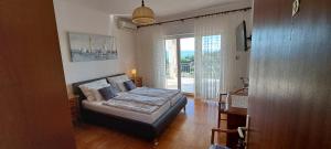 a bedroom with a bed and a large window at Apartments Desiree & Daniel in Dramalj