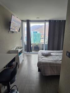 a bedroom with a bed and a desk and a window at PENINSULA DE CAVANCHA, Vista ESPECTACULAR in Iquique