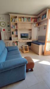 a living room with a blue couch and a tv at Ciliano 16 in Montepulciano