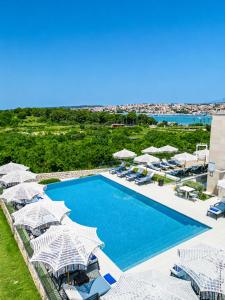 an aerial view of a resort pool with umbrellas at Hotel Joel in Novalja