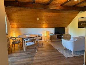 a living room with a table and a couch at Ferienwohnung Bergblick Bad Staffelstein in Bad Staffelstein +49 photos
