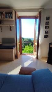 a living room with a blue couch and a large window at Ciliano 16 in Montepulciano