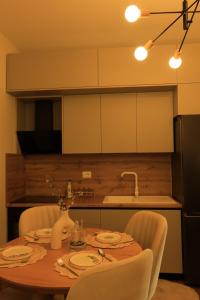 a dining room table with chairs and a kitchen at Green Hill Villa in Tirana
