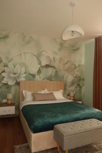 a bedroom with a bed with a flower mural on the wall at Green Hill Villa in Tirana +26 photos