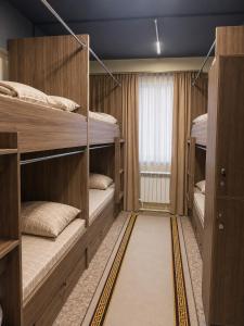 a room with three bunk beds and a window at Global Hostel in Almaty