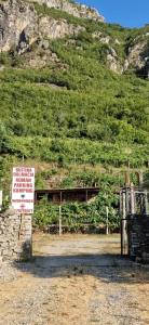 a sign that is in front of a mountain at Bujtina Dalmacia in Shkodër