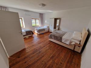 a bedroom with two beds and a wooden floor at Bujtina Dalmacia in Shkodër