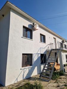 a white building with a staircase in front of it at Bujtina Dalmacia in Shkodër