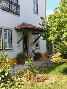 a white house with windows and plants in front of it at St Mary House in Tomar