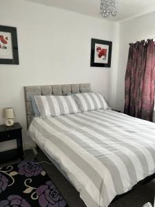 a bedroom with a large bed with striped sheets at Affordable Saundersfoot Holidays in Pembrokeshire