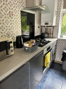 a kitchen counter with a stove and a microwave at Affordable Saundersfoot Holidays in Pembrokeshire