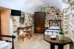 a room with two beds and a table and a mirror at Stratis Tower Since 1892 in Oitylo