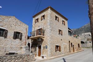 a large stone building with a balcony on a street at Stratis Tower Since 1892 in Oitylo