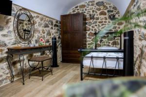 a bedroom with a bed and a vanity and a mirror at Stratis Tower Since 1892 in Oitylo