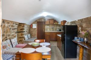 a kitchen with a table and a black refrigerator at Stratis Tower Since 1892 in Oitylo