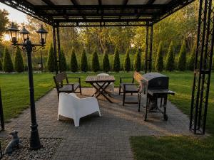 a patio with a table and chairs and a grill at Gościniec Piast Pokoje i Camper Park in Brzeźno