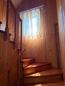 a staircase in a wooden cabin with a window at Casa de Vacanță Haneș - Private Cabin - Orchard & Mountain Views - Transalpina & viaTransilvanica in Pianu de Sus +31 photos