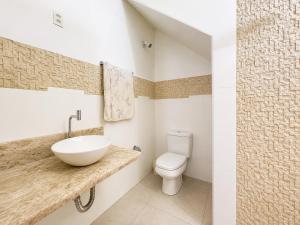 a bathroom with a sink and a toilet at Pousada Miriam in Limeira