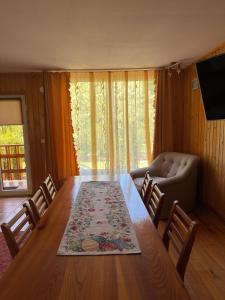 a living room with a table and a couch at Casa de Vacanță Haneș - Private Cabin - Orchard & Mountain Views - Transalpina & viaTransilvanica in Pianu de Sus