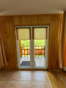an empty room with sliding glass doors with a patio at Casa de Vacanță Haneș - Private Cabin - Orchard & Mountain Views - Transalpina & viaTransilvanica in Pianu de Sus