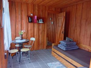 a room with a bed and a table and chairs at Atpūtas vieta- Mini ZOO BUKI in Vārve