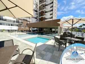 a patio with a table and chairs and a swimming pool at Spazzio diRoma in Caldas Novas