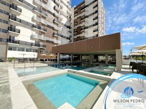 a swimming pool in front of a building at Spazzio diRoma in Caldas Novas