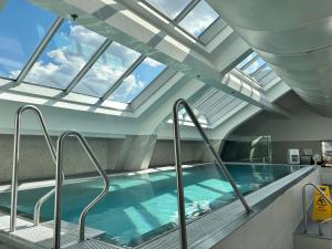 an indoor swimming pool with a skylight at Sarah's Home with POOL, WELLNESS in Budapest