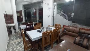a dining room with a table and chairs and a couch at Bluemoon Stay in Uttarkāshi