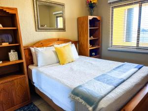 a bedroom with a bed with a wooden headboard and a mirror at Sandy Beach Princesa B309 Ocean Front Resort in Puerto Peñasco