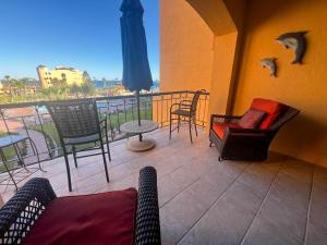 a balcony with chairs and a table and an umbrella at Sandy Beach Princesa B309 Ocean Front Resort in Puerto Peñasco