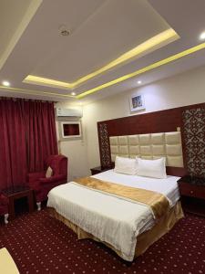 a hotel room with a large bed and a chair at Asus Al Taj Serviced Apartments in Baish +24 photos