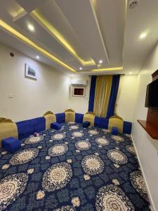 a conference room with a blue couch and chairs at Asus Al Taj Serviced Apartments in Baish