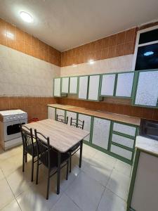 a kitchen with a wooden table and chairs at Asus Al Taj Serviced Apartments in Baish