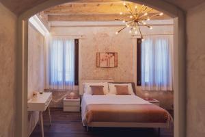 a bedroom with a large bed and a chandelier at Casa Tonello B&B in Zugliano +21 photos