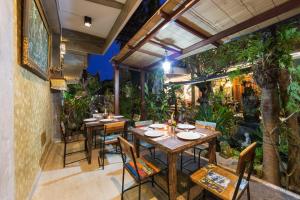 restauracja ze stołami, krzesłami i roślinami w obiekcie Sandat Bali Ubud w mieście Ubud