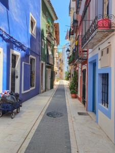 an empty street in an alley with colorful buildings at Casa chispa in Águilas