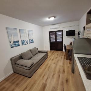 a living room with a couch and a kitchen at Rumora Ivan Apartment in Povljana