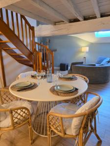 a dining room with a table and chairs at L'Écrin Historique - Duplex - Vieux Chaumont in Chaumont