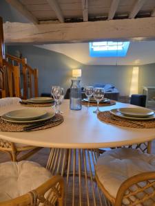 a table with plates and wine glasses on it at L'Écrin Historique - Duplex - Vieux Chaumont in Chaumont +3 photos