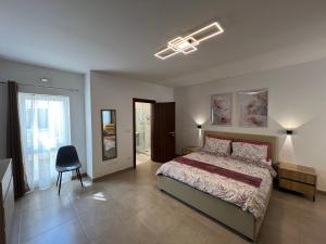 a bedroom with a bed and a chair in it at Pergola Penthouse Xaghra in Xagħra