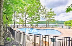 a swimming pool with a fence next to a lake at Lake Life Adventures 4 Bedroom Home in Lake Harmony