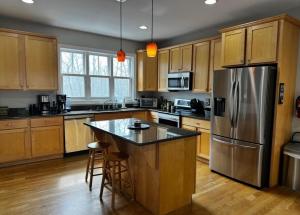 a kitchen with wooden cabinets and a stainless steel refrigerator at Lake Life Adventures 4 Bedroom Home in Lake Harmony
