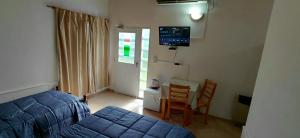 a bedroom with a bed and a table and chairs at La Vilma Hospedaje Familiar in Paganini
