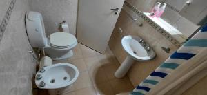 a bathroom with a white toilet and a sink at La Vilma Hospedaje Familiar in Paganini +26 photos