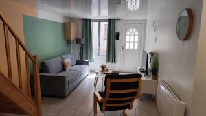 a living room with a couch and a table at À la belle étoile in Rocroi